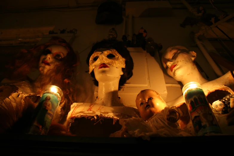 three creepy dolls sitting next to some candles