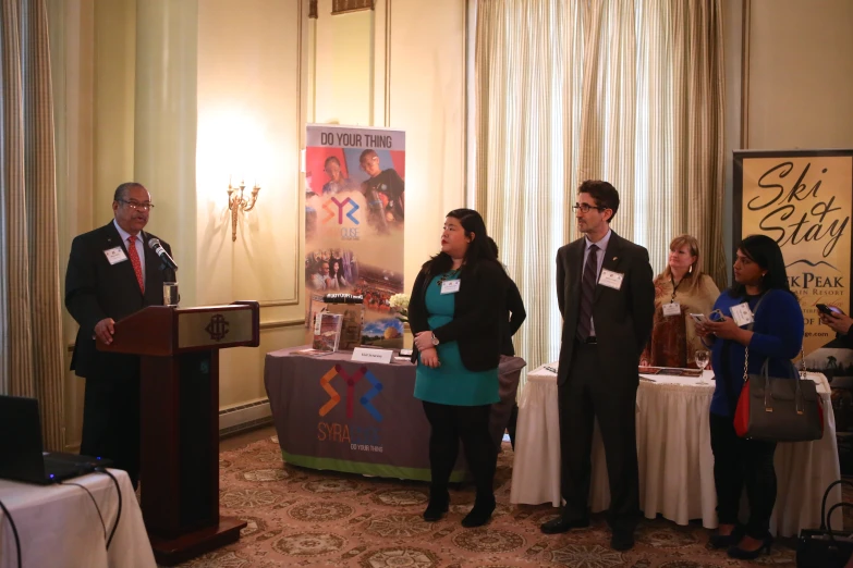 a man standing behind a podium talking at a podium