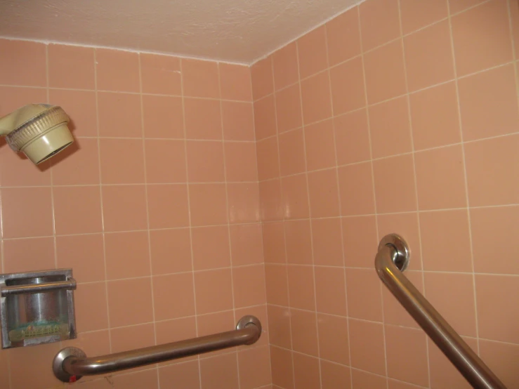 a view of a small tiled restroom with a bar