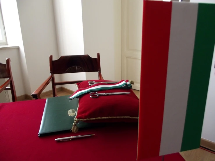 some items are laying on a red tablecloth and chair