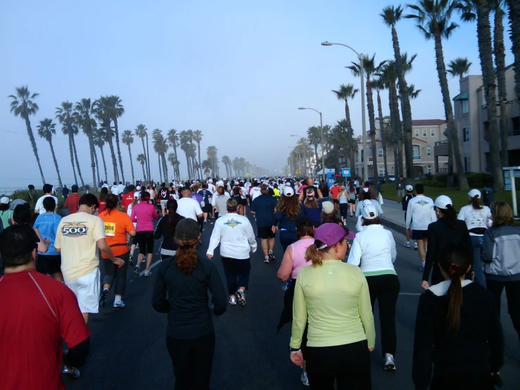 many people are running in the street as the sun sets