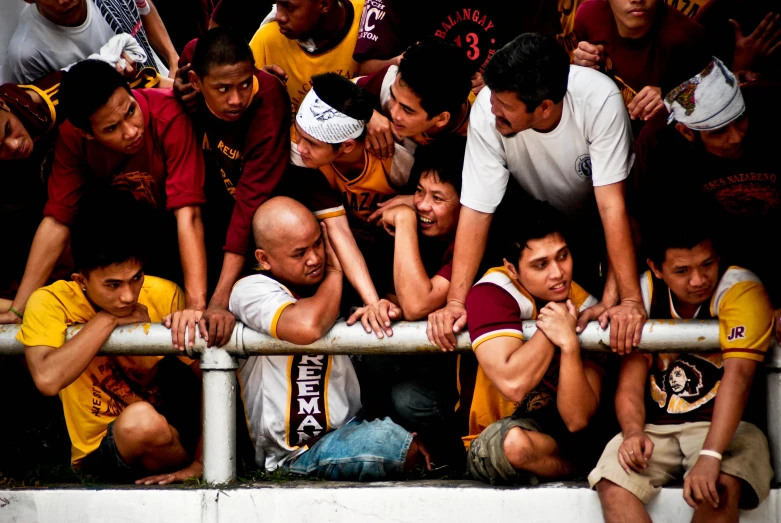 many people are sitting in a dugout with one man reaching down