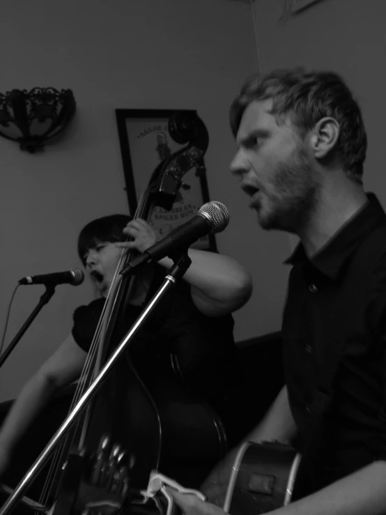 a man playing the guitar while a woman sings