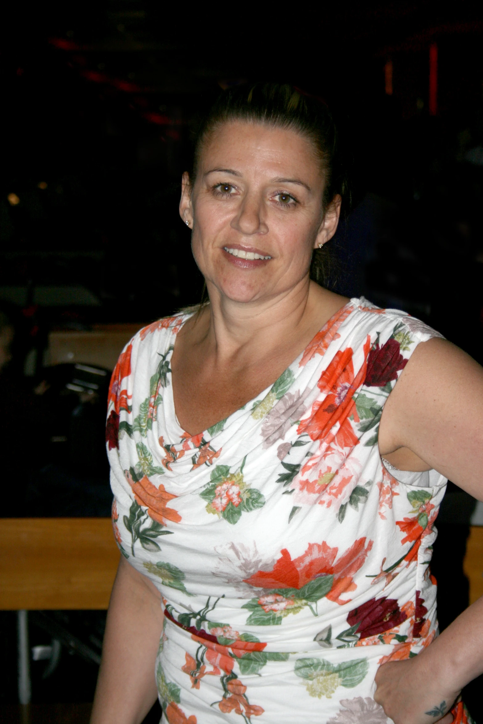 a woman wearing a white and orange flower print dress