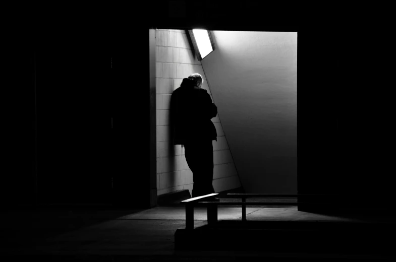 person standing alone in a room with their head down