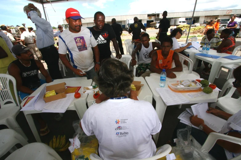 a group of children and adults sitting at small white tables