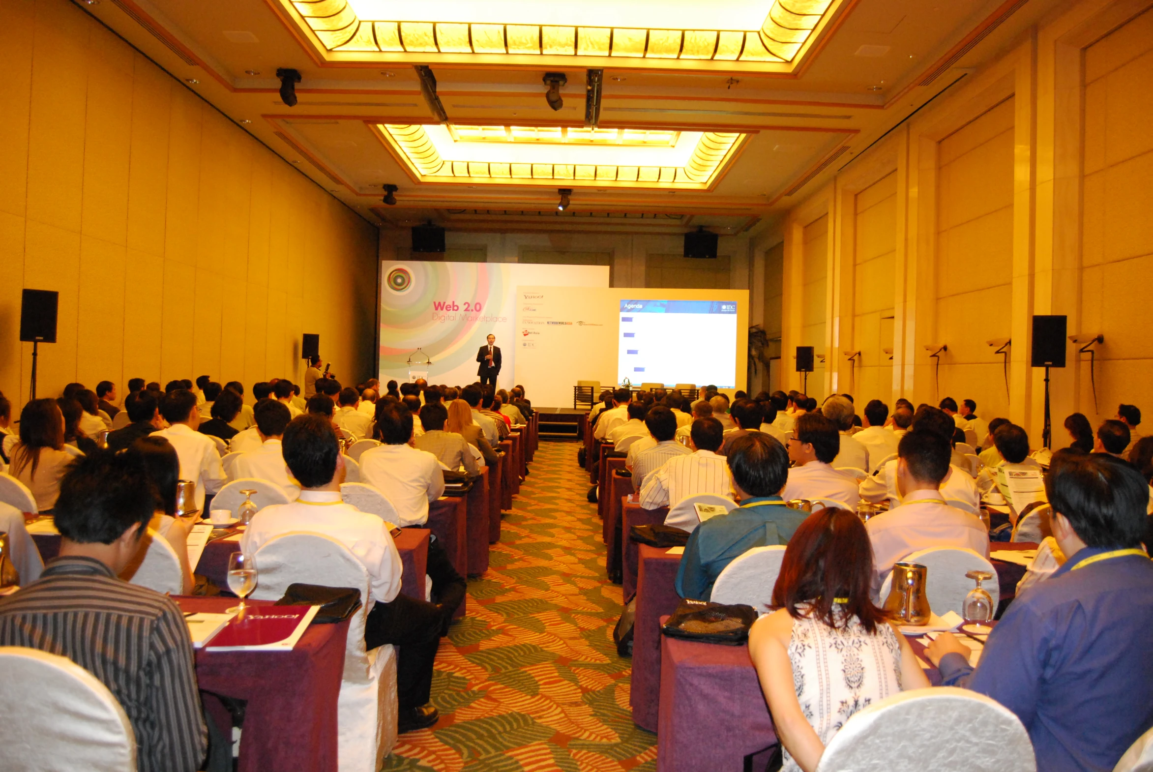 a group of people sitting at table during a presentation