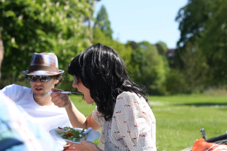 two people that are sitting down eating food