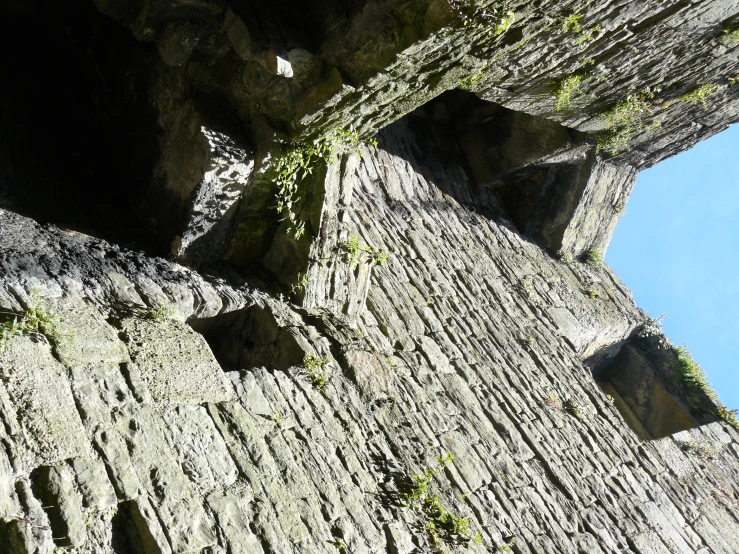 an image of a stone wall and gate with an odd shaped door