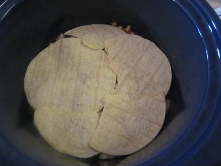 an uncooked tortilla in a blue slow cooker