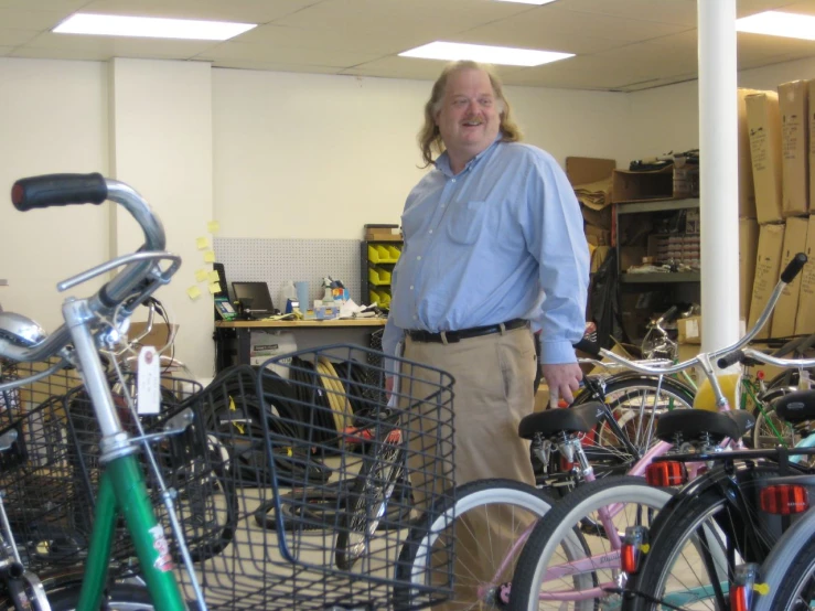 a man standing next to his bicycle inside a shop