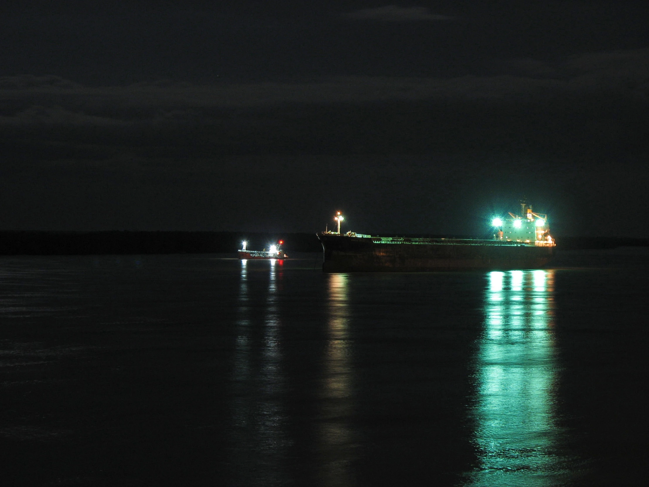 some boats that are in the water at night