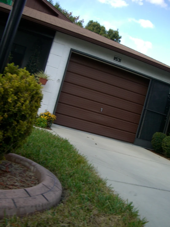 a garage door in a residential area with landscaping