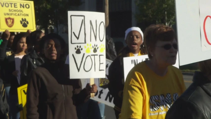 people holding signs in protest on the street