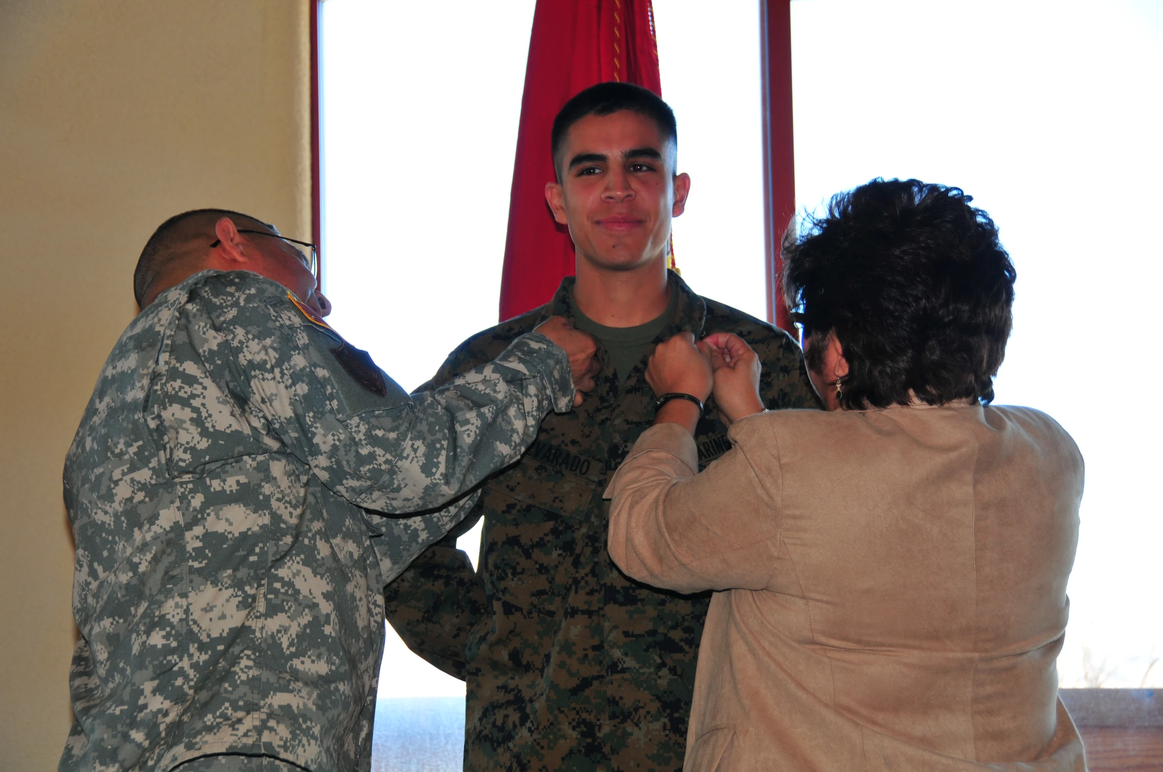 two men are helping a woman get ready