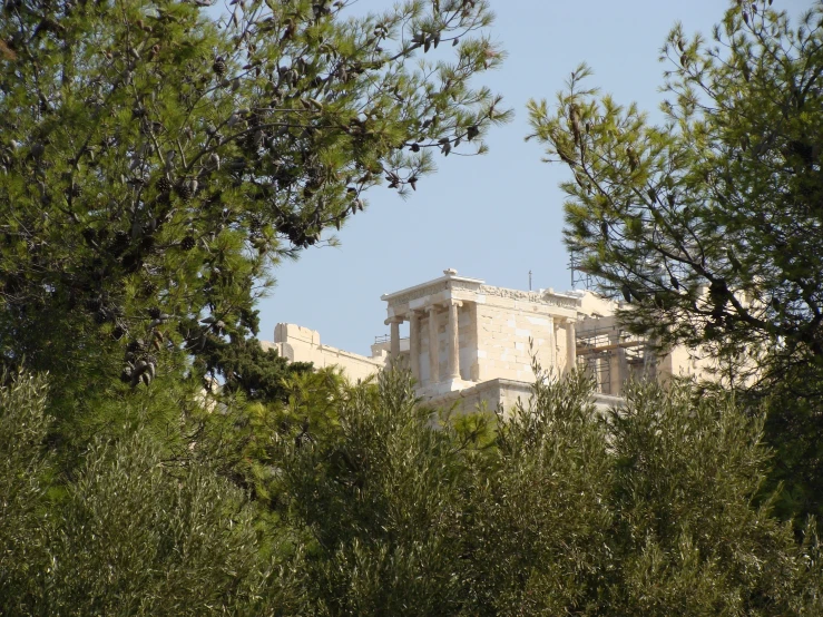 the building is behind many trees, and it's white