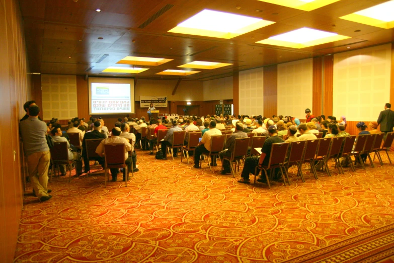 a group of people sitting at tables in a large room