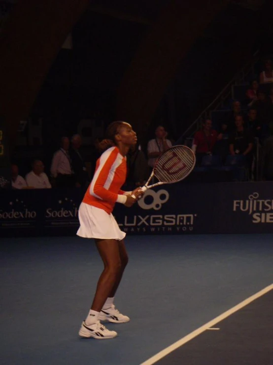 a woman holding a tennis racquet on top of a tennis court