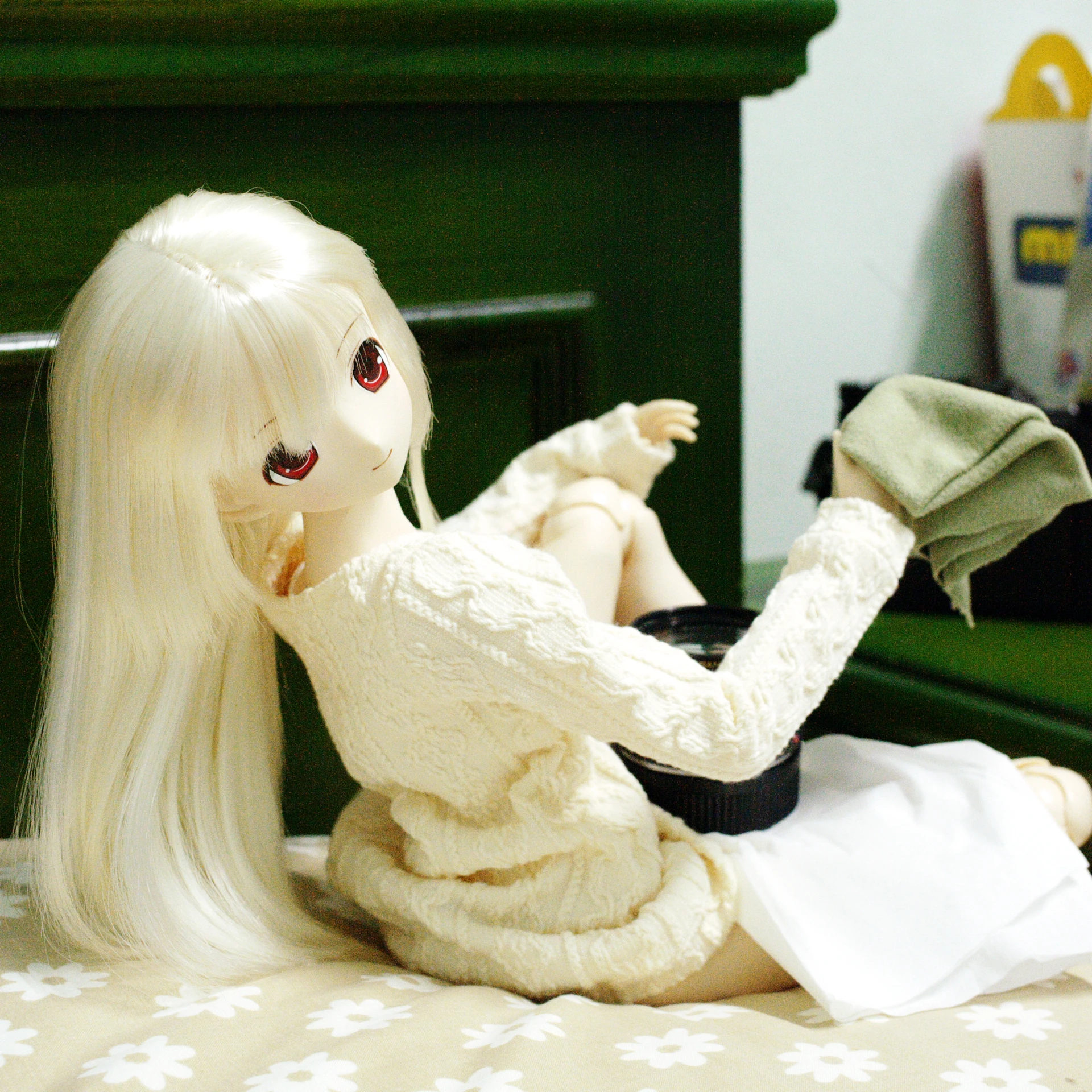 the doll is sitting on a bed with her dress flowing