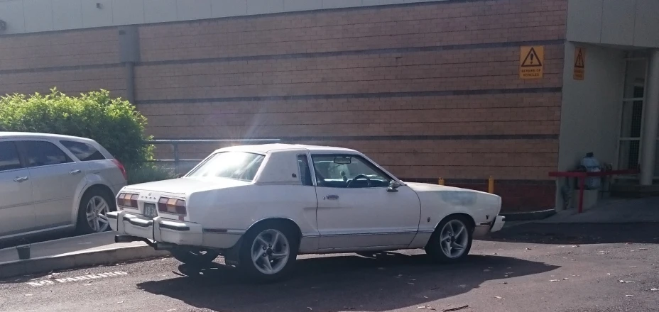 a car is being towed down a parking lot by a truck