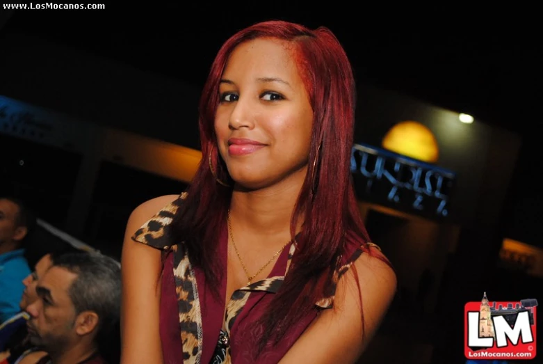 woman with long red hair smiling at camera