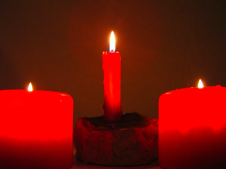 red candles glowing against the dark background