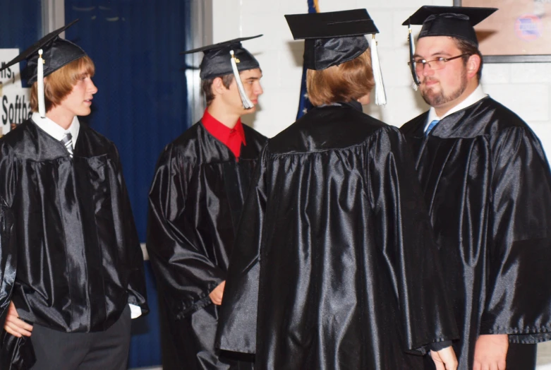 a group of boys and girls wearing black graduation gowns