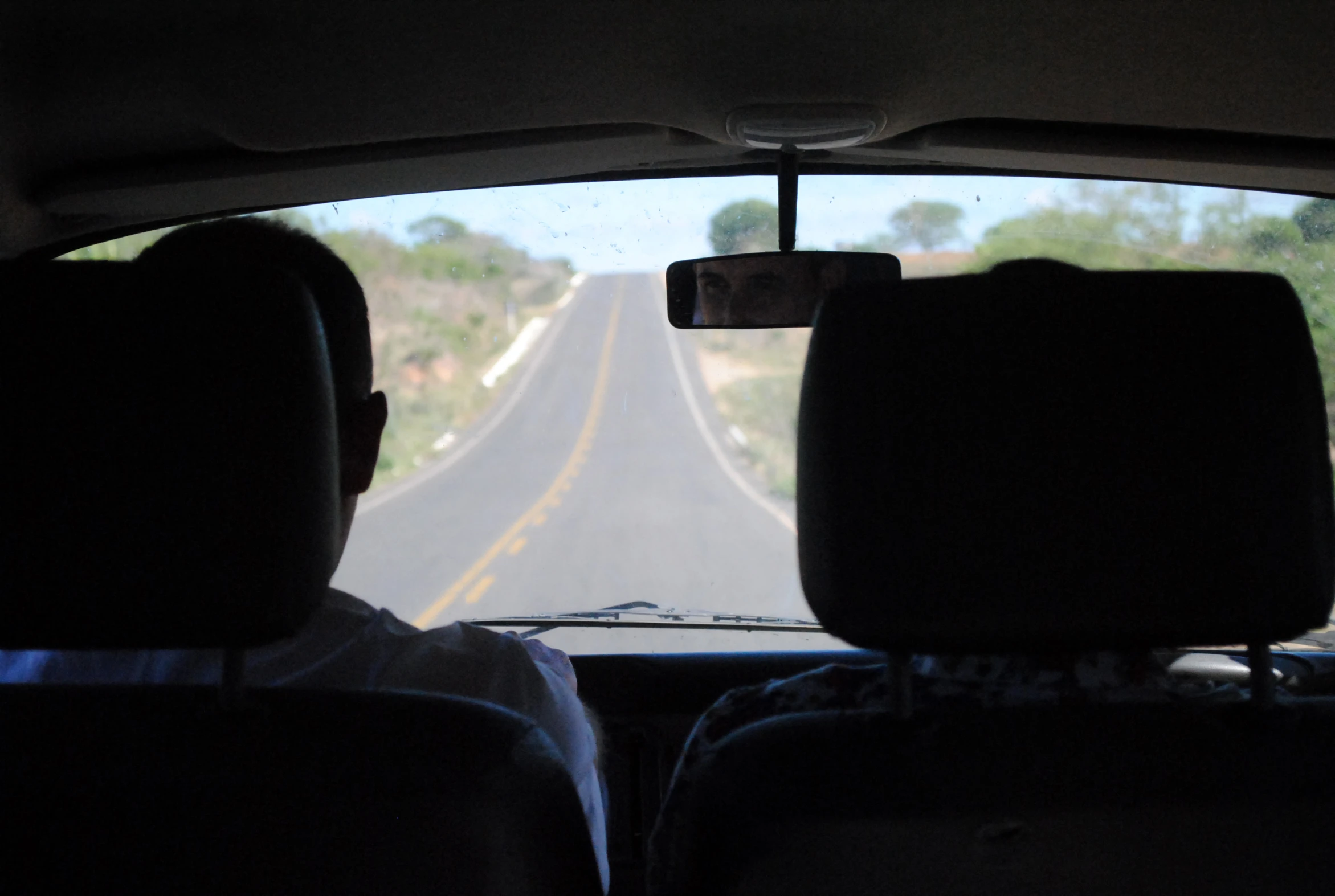 two people sitting in a car with the sun out