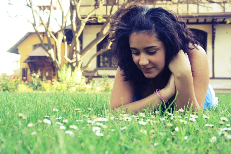 a woman laying on the grass and looking down