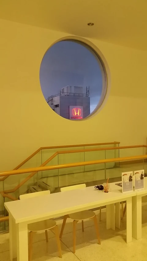 a white table with benches around it in front of a circular window