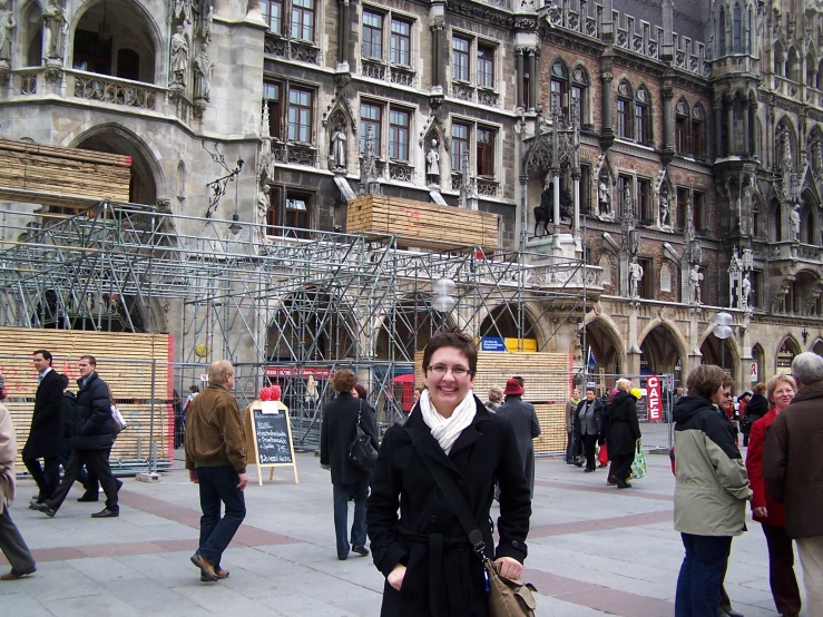 a woman is standing outside a huge building