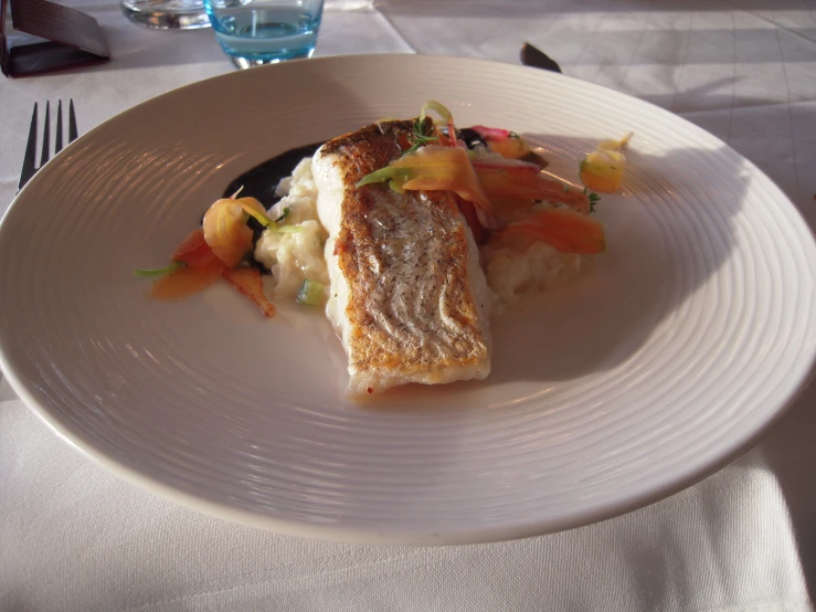 a small white plate topped with a fish