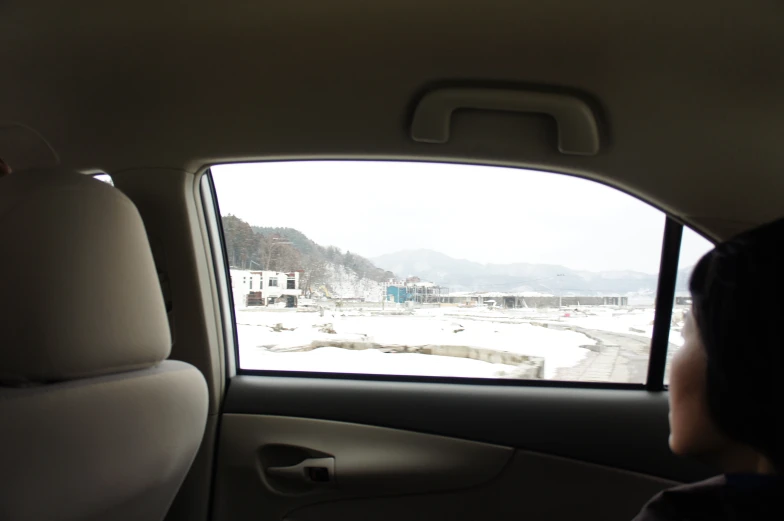 a man and a woman in their vehicle looking at snow