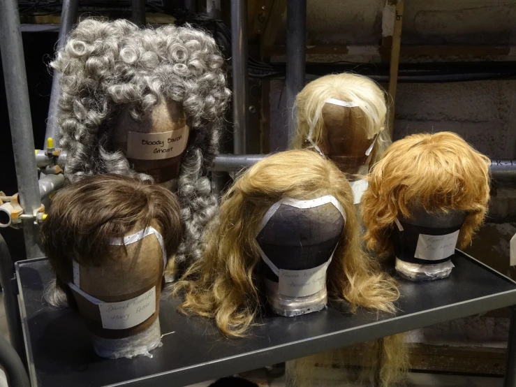 a display case with various wigs and hair on it