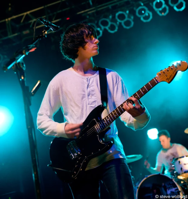 a person holding onto a guitar in a band