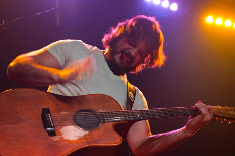 a man is playing his guitar at a concert