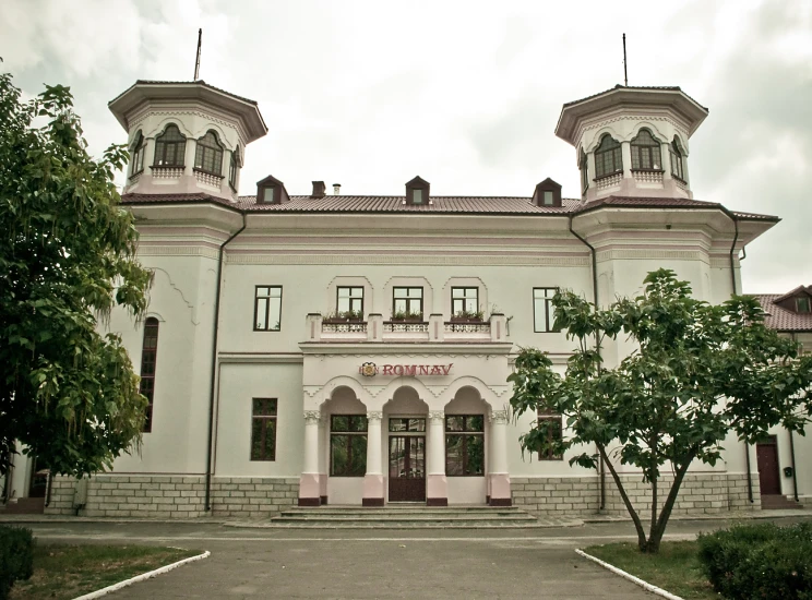 an ornately designed white building with two stories