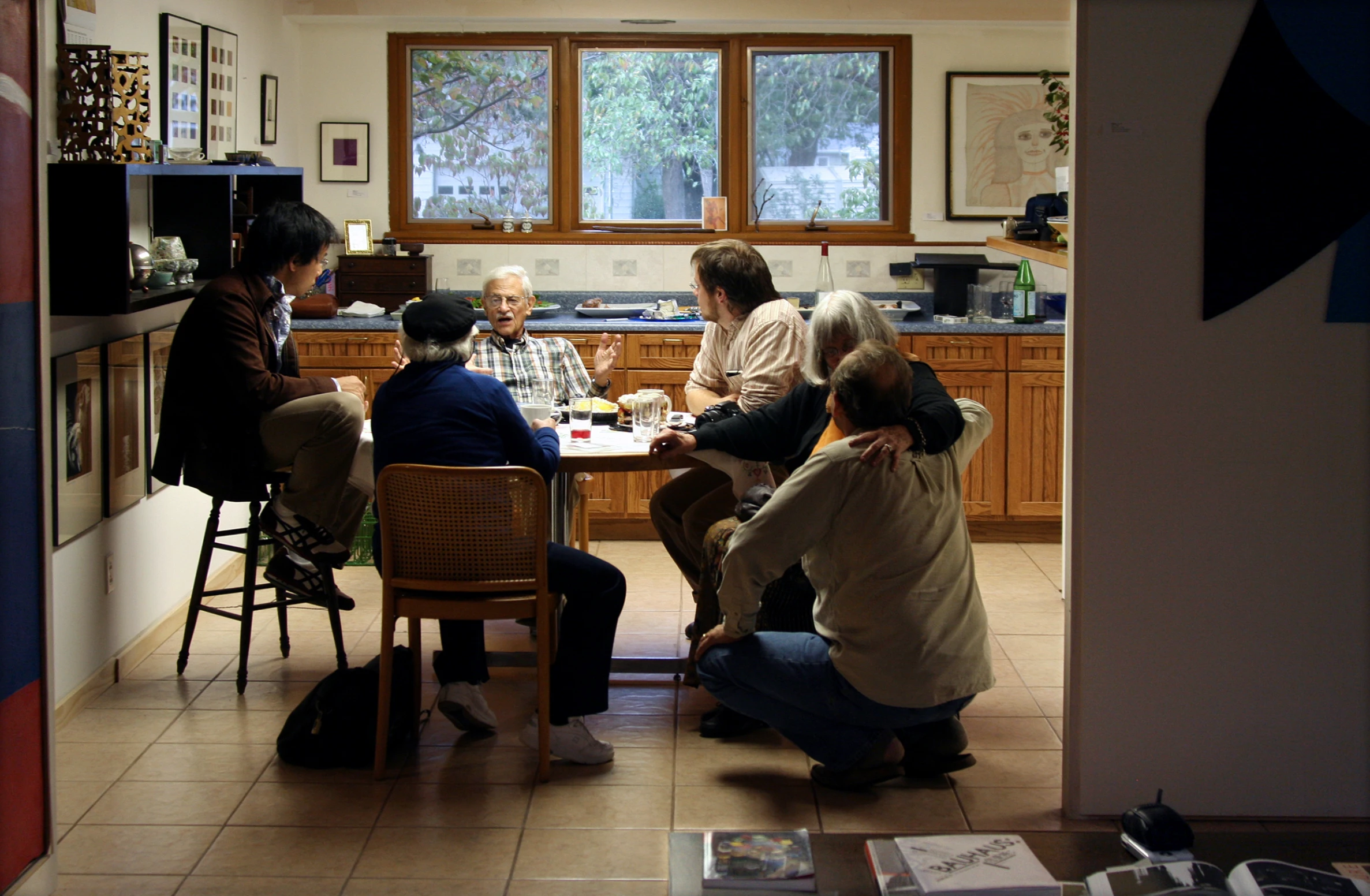 a family is sitting around a table in the kitchen