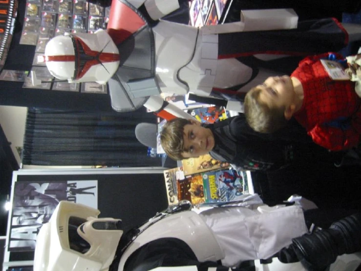 two boys pose beside some costumes for halloween