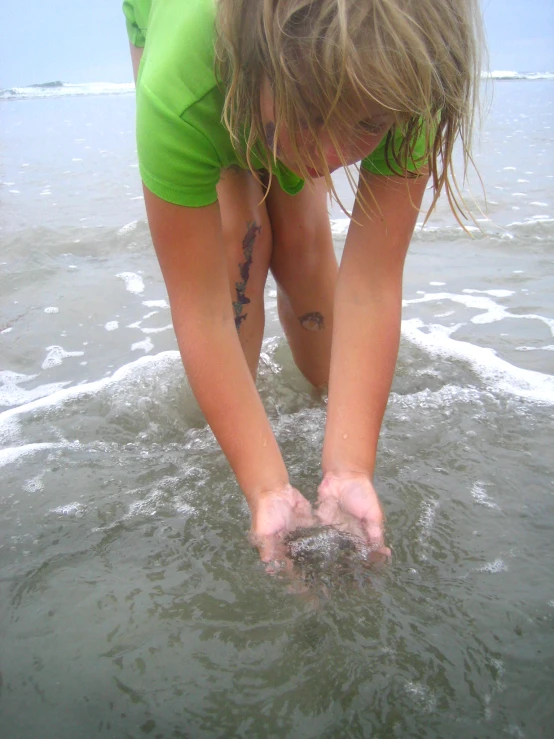 woman reaching for soing in the ocean from shore