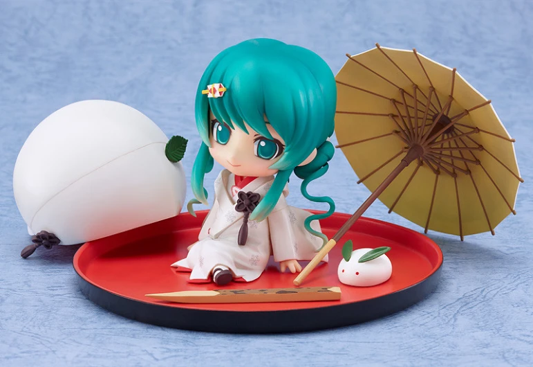 a cute doll with green hair sitting on a tray with an umbrella