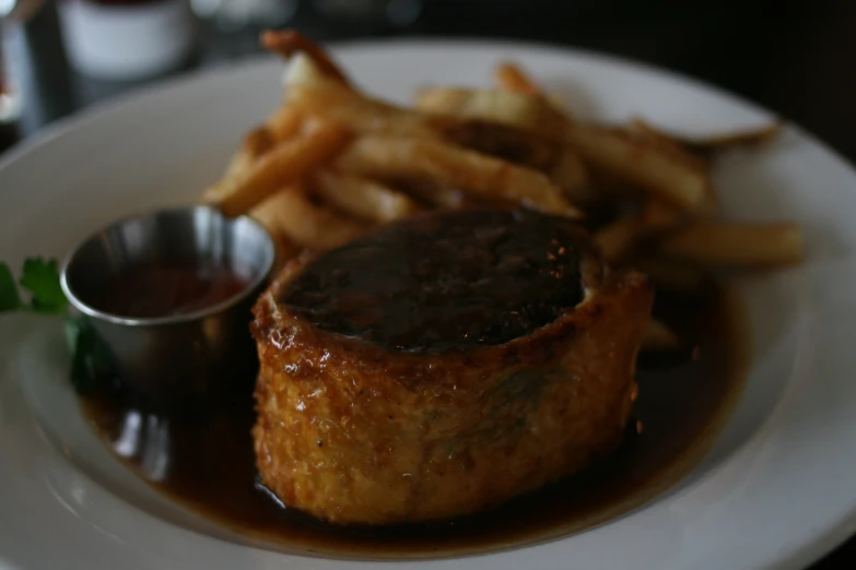 small stack of food on a plate with french fries