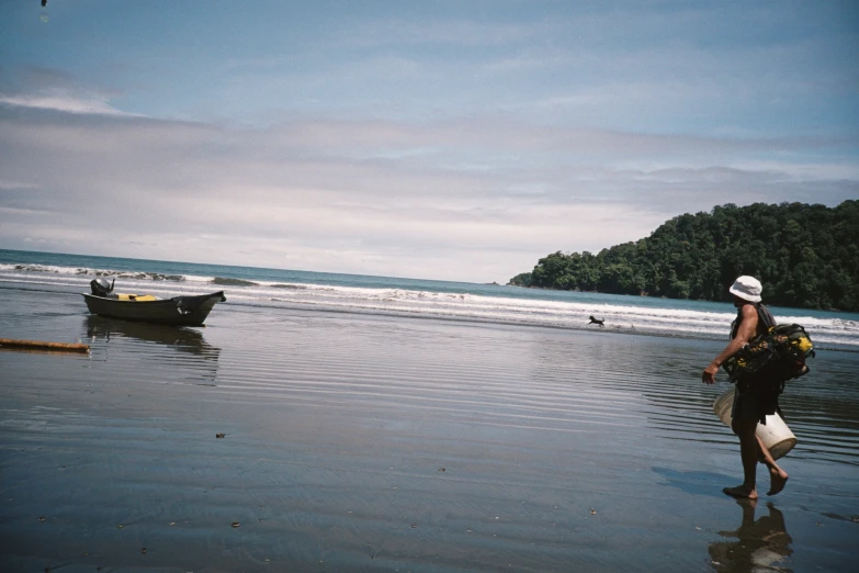 a man is standing on the beach next to boats