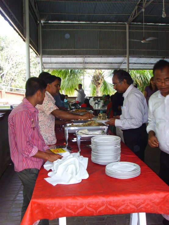 a group of people are standing around a table