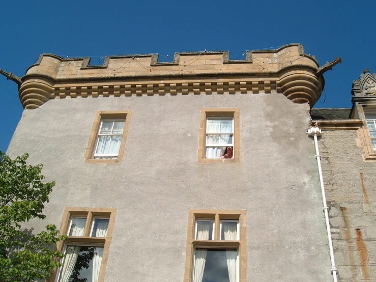 an old castle building with two windows and an open cat on the ground