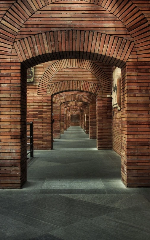 brick tunnel between buildings with benches on both sides