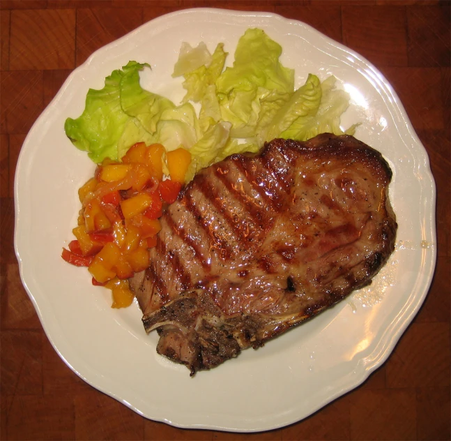 a plate of steak and lettuce on a table