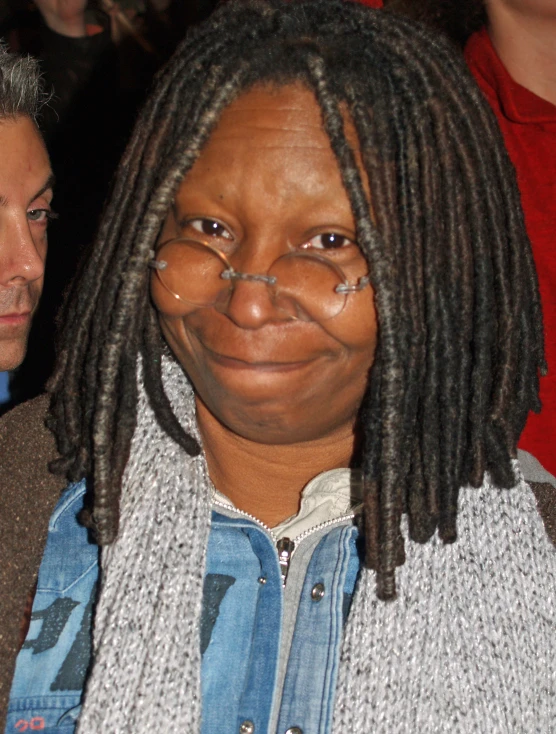 a woman wearing glasses and a shirt with dreadlocks