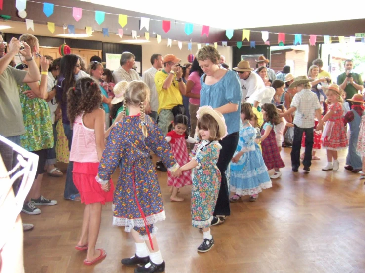 several people are dancing around a group of children