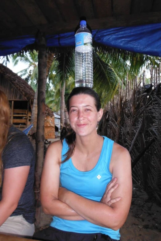 a woman wearing a blue top sitting under a shade umbrella